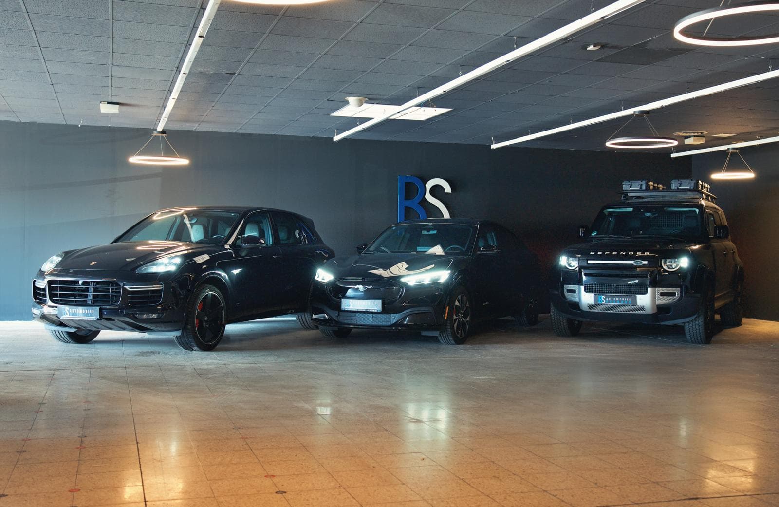 Showroom von BS Automobile mit mehreren Fahrzeugen in dramatischer Beleuchtung